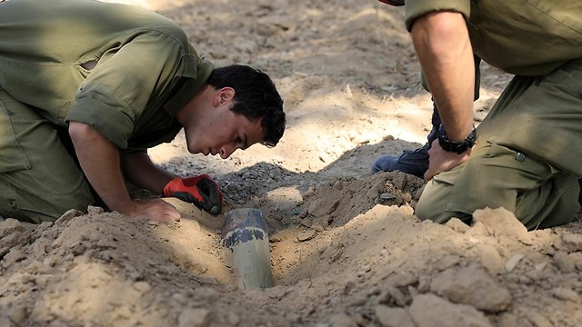 IDF soldiers examine rocket fired from Gaza last week (Photo: AP)
