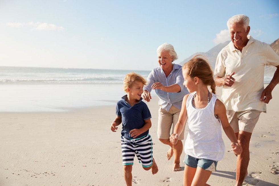 סבא וסבתא רצים עם הנכדים על חוף הים (צילום: Shutterstock)