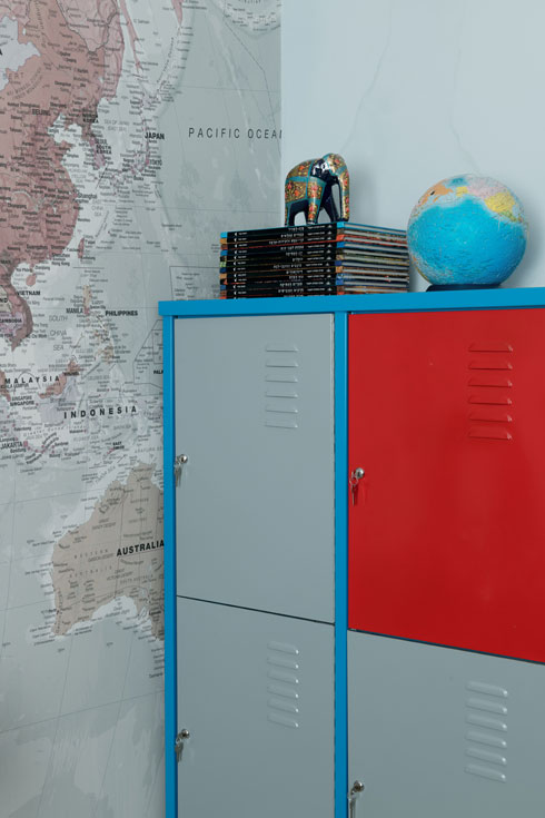 בחדרו של הבן לוקרים באדום ואפור לצד טפט מפת העולם (צילום: גדעון לוין)