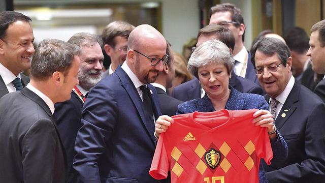 British Prime Minister May receives Belgium national team shirt from Belgian Prime Minister Michel after they defeated England in the World Cup (Photo: AP)