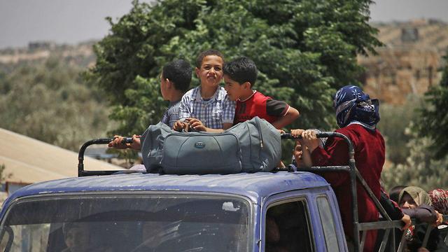 אזרחים עוזבים את בתיהם בעיר דרעא (צילום: AFP)