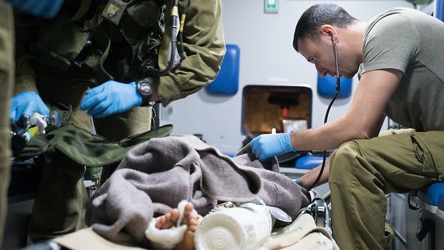 Израильский военврач осматривает раненого сирийца. Фото: пресс-служба ЦАХАЛа
