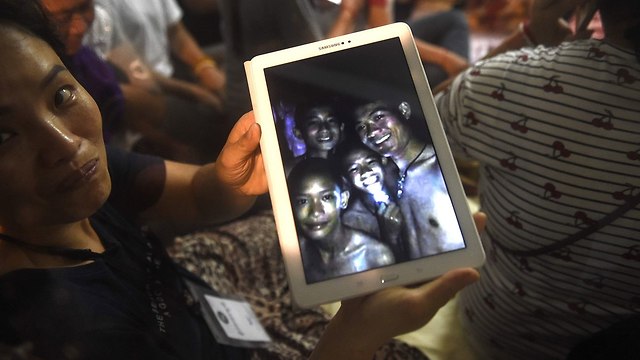בני משפחה של הנערים הכדורגלנים שנמצאו חיים במערה ב תאילנד (צילום: AFP)