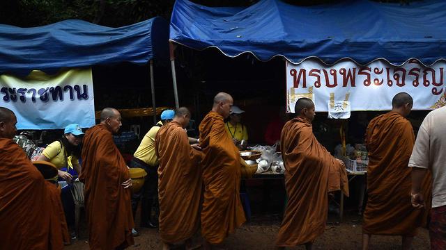 כמרים בודהיסטים סמוך לזירת החילוץ (צילום: AFP)