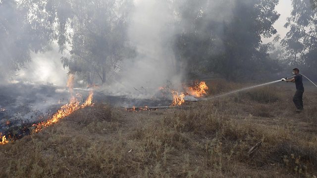 Bomberos que luchan contra incendios en Kissufim a causa de un globo incendiario (Foto: AFP)