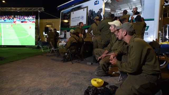 IDF soldiers watch a World Cup football match at the Syrian border