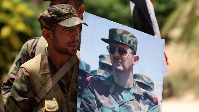 Сирийский солдат с портретом Асада. Фото: EPA