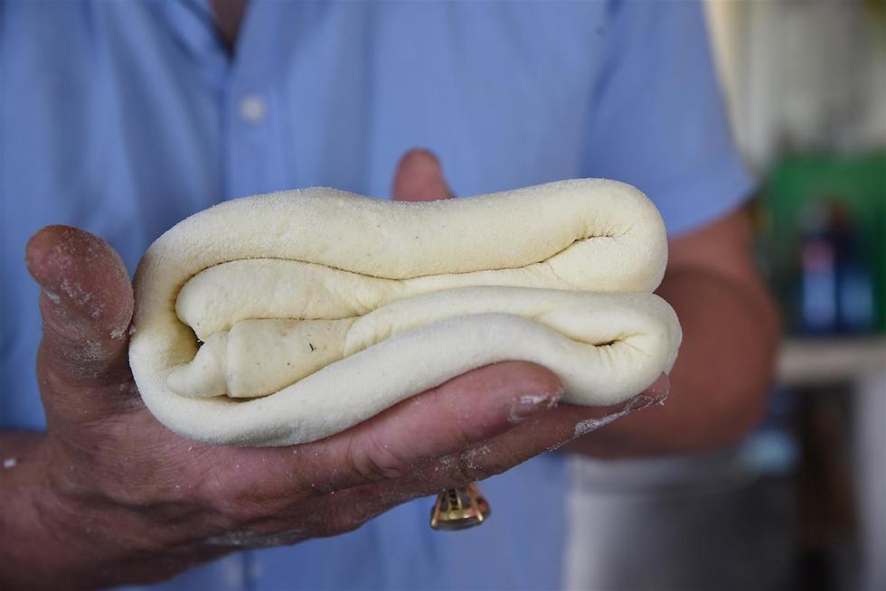 ארז קומרובסקי אופה לחם מטבוחה (צילום: אביהו שפירא)