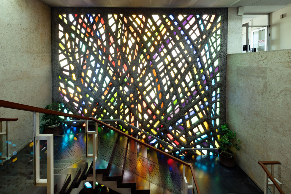המדרגות משתרגות לצד קיר זכוכית ובטון מרהיב שיצרה האמנית נעמי הנריק, קיר שמתרגם את אור השמש לתאורה צבעונית, רכה ואלגנטית (צילום: גדעון לוין)