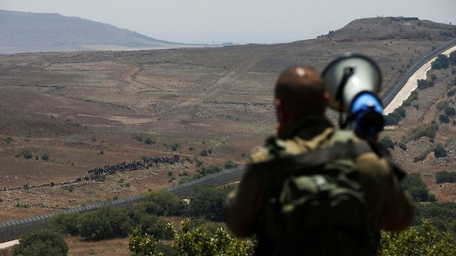 IDF soldier urges Syrians to turn around (Photo: Reuters)