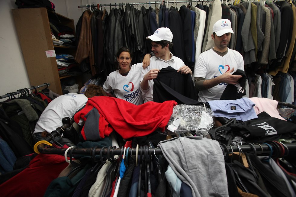 מתנדבים מסייעים במיון בגדים בביגודית ויצו ()