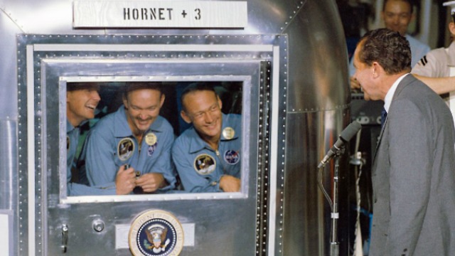 שלושה שבועות של בידוד. הנשיא ניקסון משוחח עם האסטרונאוטים על סיפון נושאת המטוסים (צילום: נאס