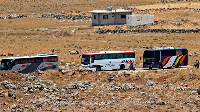 אוטובוסים בסוריה ליד גבול ישראל רמת הגולן מובילים מורדים צפונה (צילום: AFP)