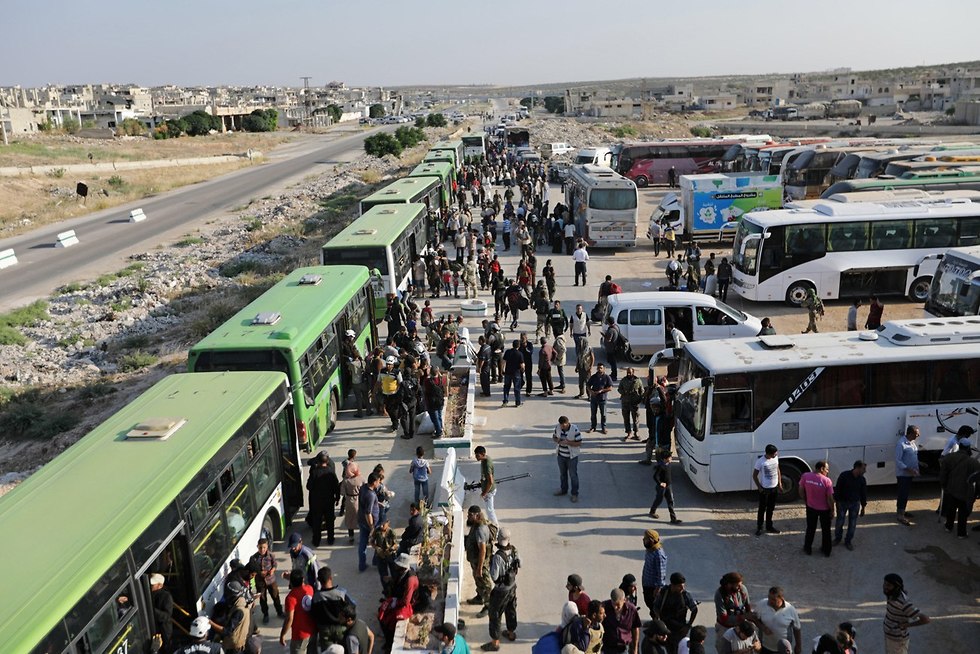 מורדים ובני משפחותיהם מגיעים ממחוז דרעא בדרום סוריה למחוז חמה (צילום: רויטרס)