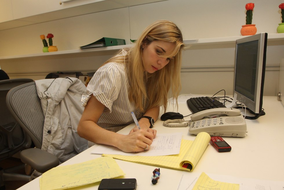 אישה כותבת בכתב יד מול מחשב ()