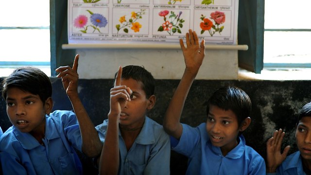 ילדים הודים מצביעים בבית ספר (צילום: AFP)