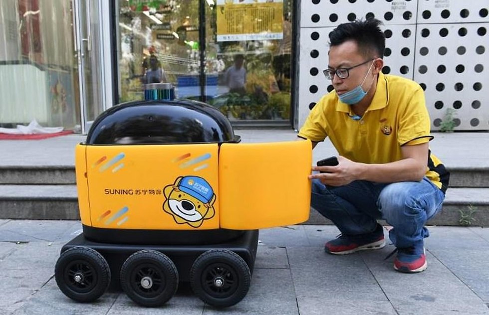 רובוט ב סין בייג'ינג מביא חטיפים עד דלת הבית (צילום: AFP)