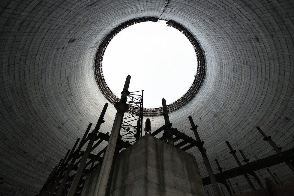 הדמות של הצלם מחייה את מבנה הקירור של תחנת כוח גרעינית בצ'רנוביל (צילום: דיוויד דה רואדה)