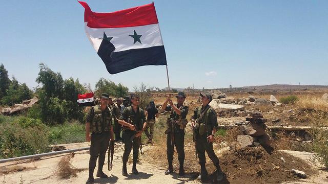 חיילים סורים עם דגל סוריה בקוניטרה (צילום: AFP)