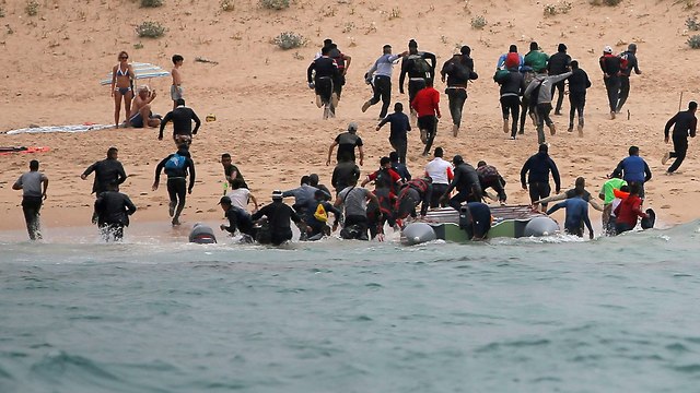 מהגרים מגיעים לחוף העיירה טריפה ב ספרד ובורחים מהמשטרה  (צילום: רויטרס)