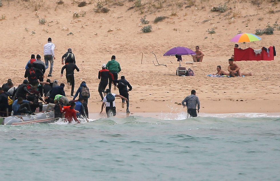 מהגרים מגיעים לחוף העיירה טריפה ב ספרד ובורחים מהמשטרה  (צילום: רויטרס)