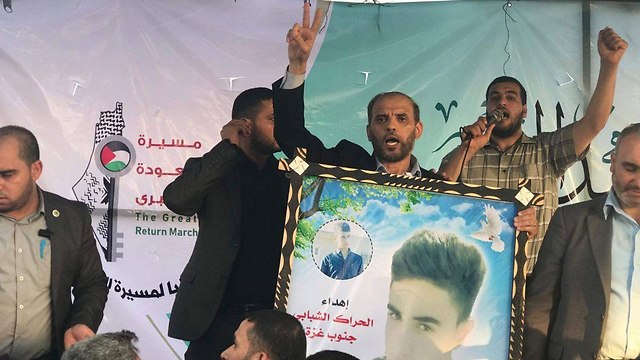 Hamas's spokesman holding a picture of a terrorist 