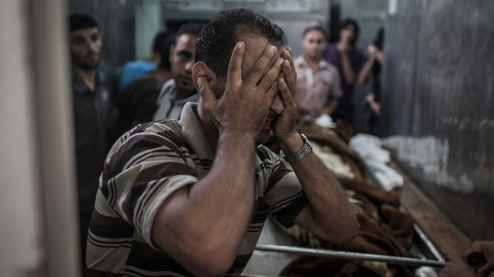 Palestinian man cries after seeing body of relative killed during Protective Edge (Photo: EPA)