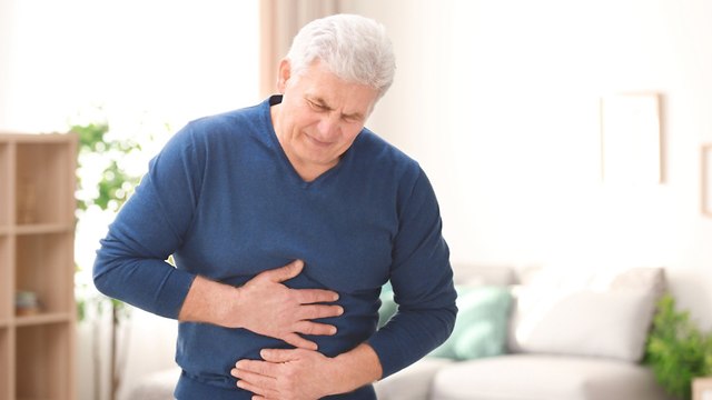 גבר עם כאב בטן וחזה (צילום: shutterstock)