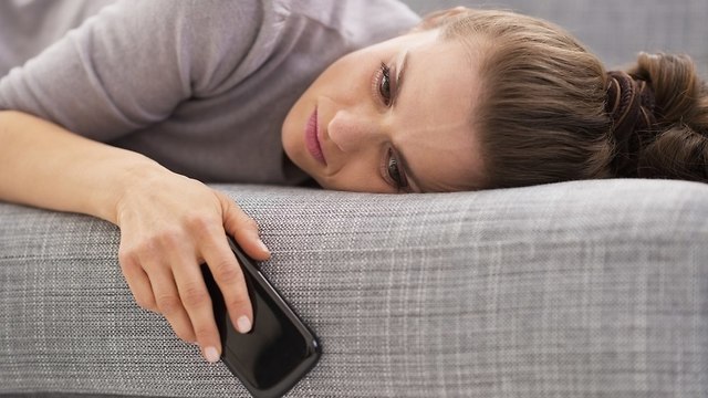 אישה מדוכאת על הספה (צילום: Shutterstock)