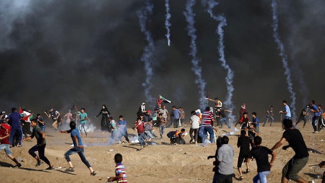 Palestinians demonstrators near the Gaza border fence (צילום: AFP)