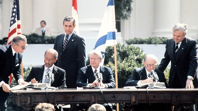 מנחם בגין, אנואר סאדאת וג'ימי קרטר בתימת הסכם השלום בין ישראל למצרים (צילום: AFP)