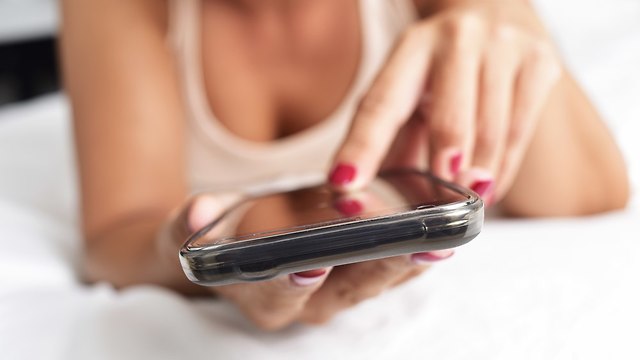 אישה מקלידה בטלפון (צילום: Shutterstock)