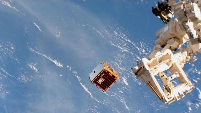הצבת הלוויין RemoveDEBRIS במסלולו בעזרת הזרוע הרובוטית של תחנת החלל הבינלאומית  (צילום: NASA/NanoRacks)