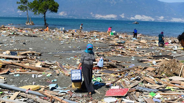 מחפשים חפצים להציל בהריסות רעידת אדמה צונאמי פאלו האי סולוואסי ב אינדונזיה (צילום: AFP)