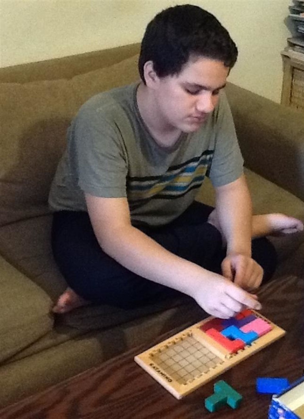 איל שחל, נער אוטיסט, משחק במשחק לוח בסלון (צילום: באדיבות המשפחה)