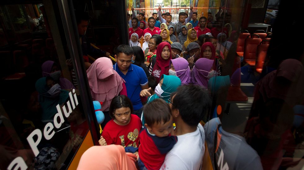 תושבים בסורביה באינדונזיה משלמים על נסיעות באוטובוס בבקבוקי פלסטיק (צילום: רויטרס)