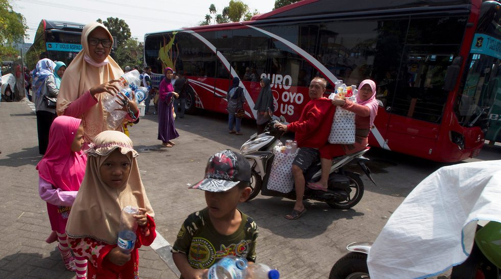 תושבים בסורביה באינדונזיה משלמים על נסיעות באוטובוס בבקבוקי פלסטיק (צילום: רויטרס)