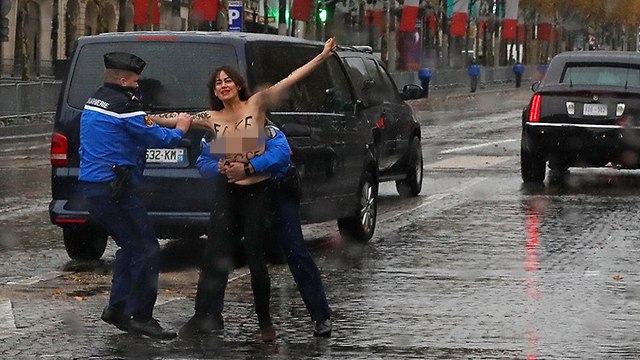 פעילה פמיניסטית FEMEN התפרצה ליד שיירה דונלד טראמפ טקס פריז מלחמת העולם הראשונה (צילום: AP)
