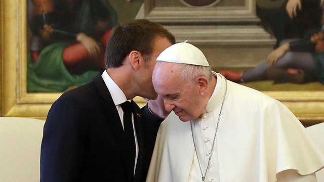 נשיא צרפת עמנואל מקרון לוחש באוזנו של האפיפיור פרנסיסקוס (צילום: AP)
