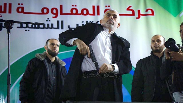 Hamas's leader in Gaza, Yahya Sinwar, waves a gun during a rally in Gaza