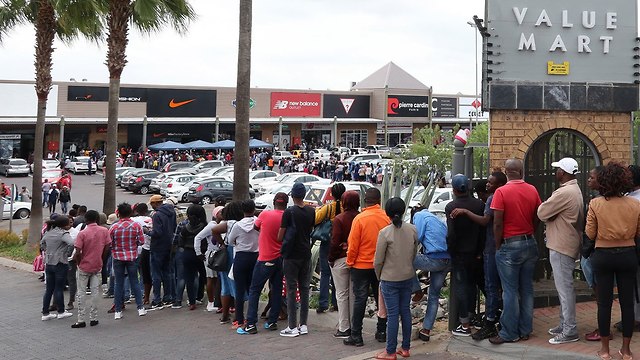 אנשים עומדים בתור כדי לקנות במבצעי בלאק פריידי בדרום אפריקה (צילום: EPA)