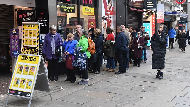 אנשים עומדים בתור כדי לקנות במבצעי בלאק פריידי בלונדון (צילום: EPA)