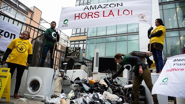 פעילי סביבה זרקו פסולת מכירי חשמל מול מטה אמזון ב קלישי צרפת בלאק פריידי (צילום: AFP)