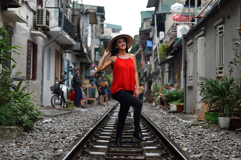 תיירים מצטלמים על פסי רכבת ב האנוי וייטנאם  (צילום: AFP)