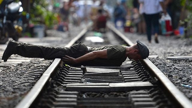 תיירים מצטלמים על פסי רכבת ב האנוי וייטנאם  (צילום: AFP)