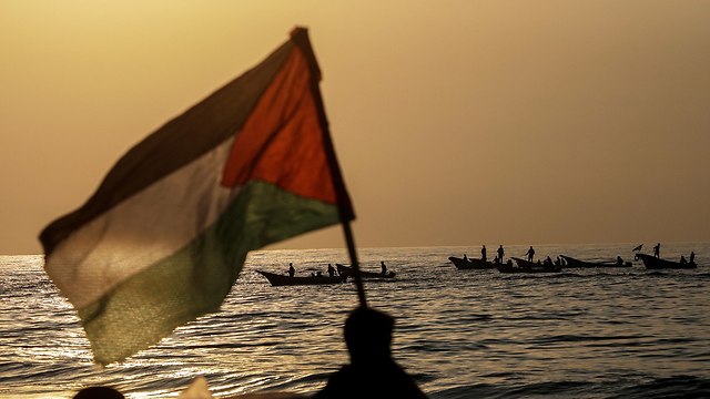 דגל הרשות הפלסטינית על חוף הים ב עזה ליד גבול ישראל (צילום: EPA)