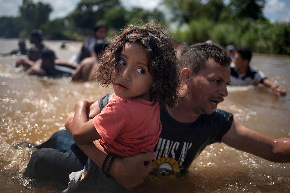 רויטרס תמונות השנה לואיס קוסטה מ הונדורס מעביר את בתו אנחל חסוס בת ה-5 דרך הנהר ממקסיקו לגואטמלה בדרך ל ארה
