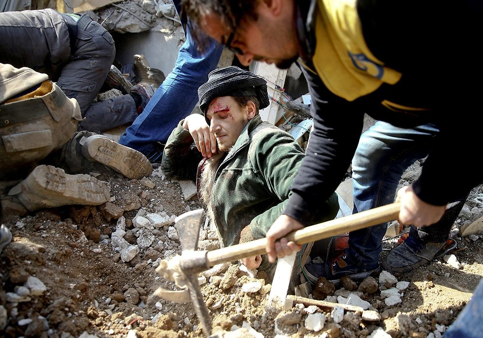 רויטרס תמונות השנה חילוץ פצוע סבקה סוריה הפצצה ינואר (צילום: רויטרס)