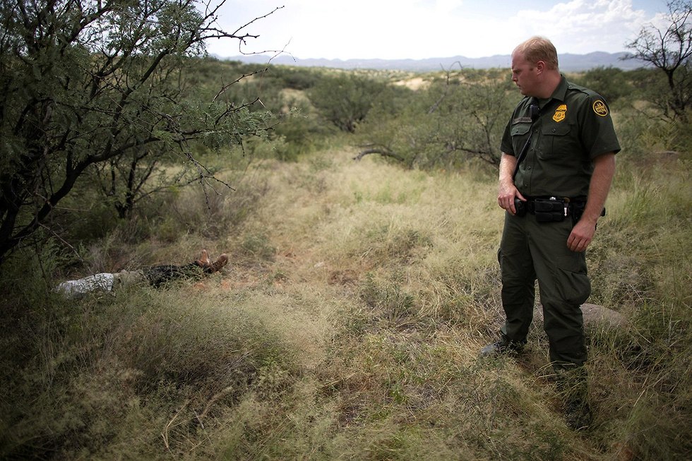 רויטרס תמונות השנה איש משמר הגבול האמריקני ג'ייקוב סטוקנברג מביט בגופת מהגר מ גואטמלה מיסאל פאיס בן 25 מת במדבר סונורן אריזונה ספטמבר (צילום: רויטרס)