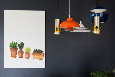 מנורות וינטג' וציור של ענת מעוז על רקע הקיר הכהה (צילום: שירן כרמל)